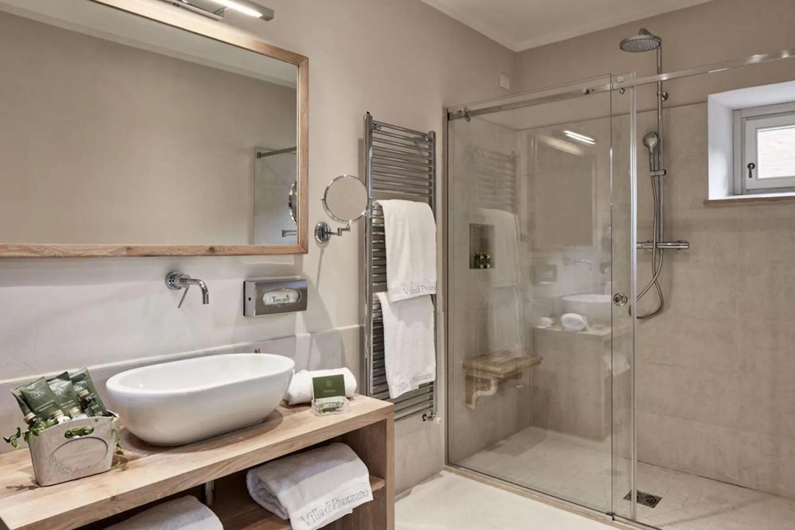 Modernes Badezimmer mit Waschtisch aus Holz, Spiegel und begehbarer Glasdusche.