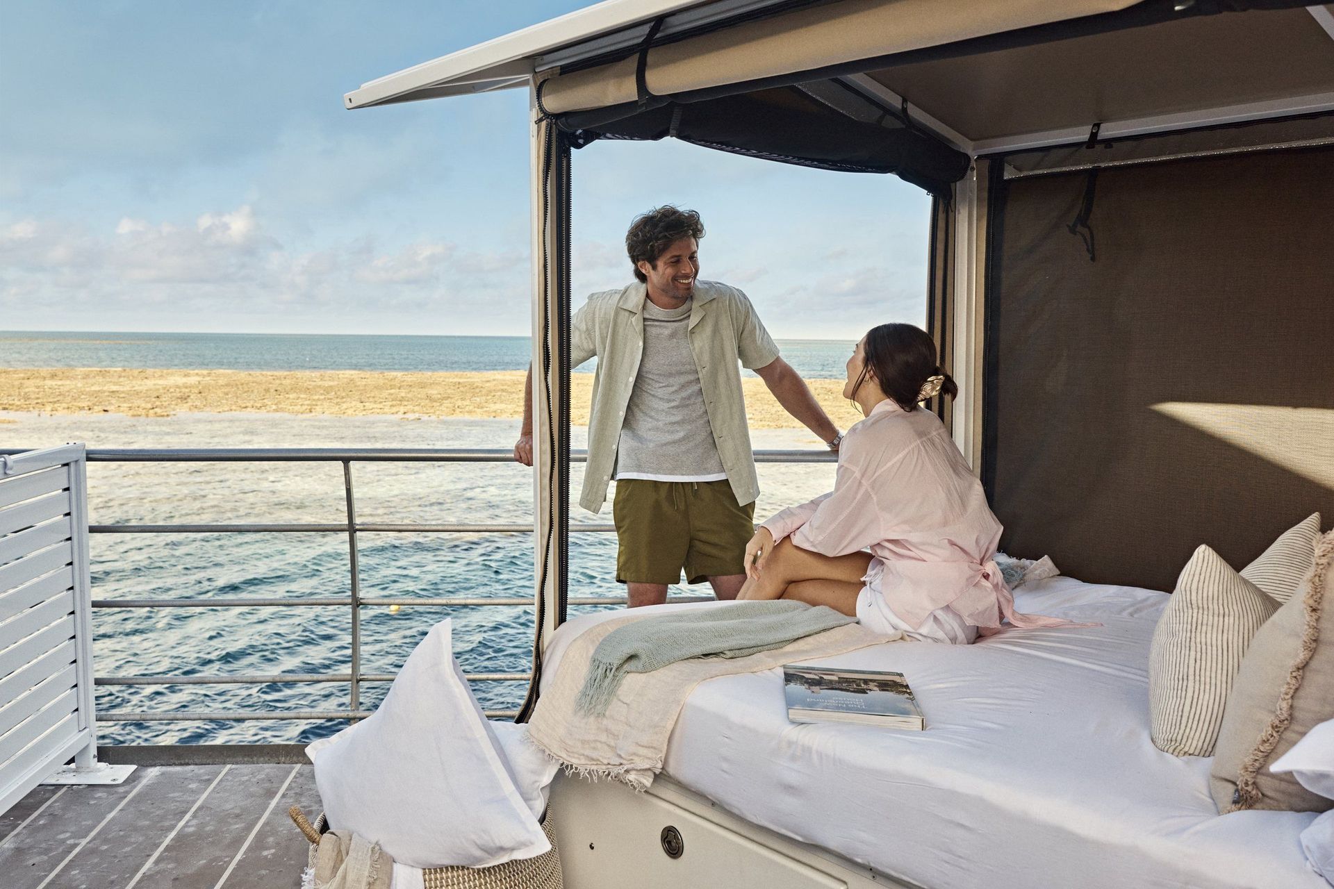 Reefsleep-Baldachinbett auf dem Oberdeck mit Meerblick, ein Paar am Bett