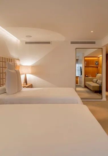Doppelzimmer mit zwei Betten und einem großen Spiegel im Raum