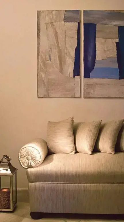 Dezente Kunstwerke über einem cremefarbenen Sofa in der Präsidenten Suite