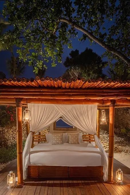 Luxuriöses Bett mit Baldachin und sanfter Beleuchtung bei Nacht.