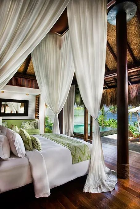 Luxuriöses Schlafzimmer mit Baldachin-Bett und offenen Blick auf tropische Landschaft