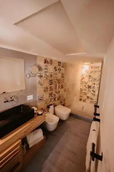 Badezimmer in der Deluxe Suite mit moderner Dusche und stilvollen Fliesen