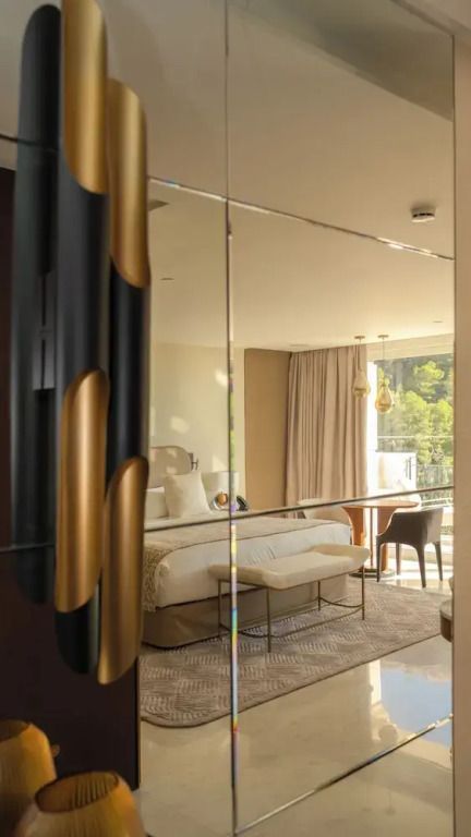 Deluxe Zimmer mit großem Bett, Spiegel und Balkon sowie moderner Einrichtung