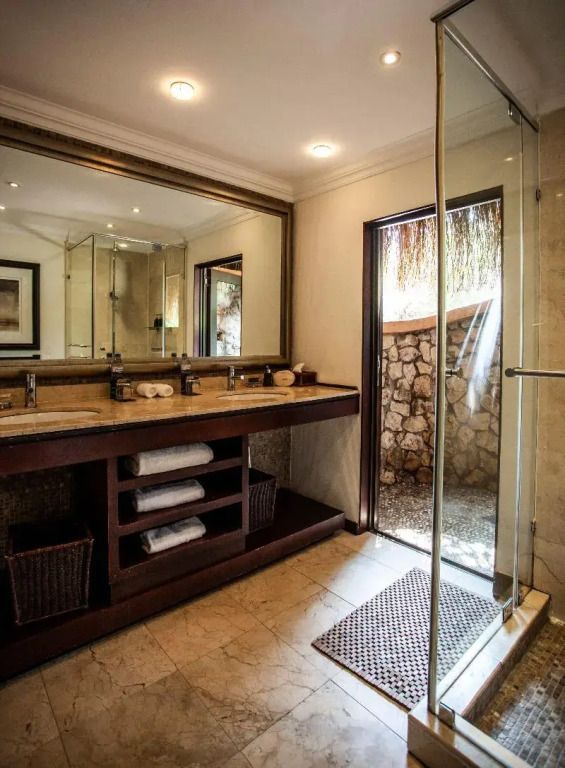 Luxuriöses Badezimmer mit Doppelwaschbecken und ebenerdiger Dusche.