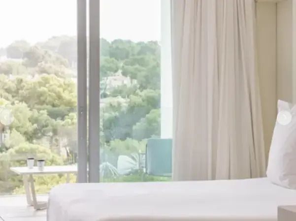 Blick aus der Suite auf grüne Landschaft mit Balkon und Fenstervorhängen