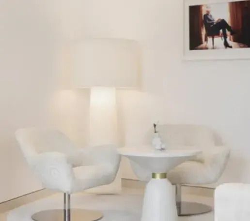 Moderne Sitzecke mit weißen Sesseln und dekorativem Tisch
