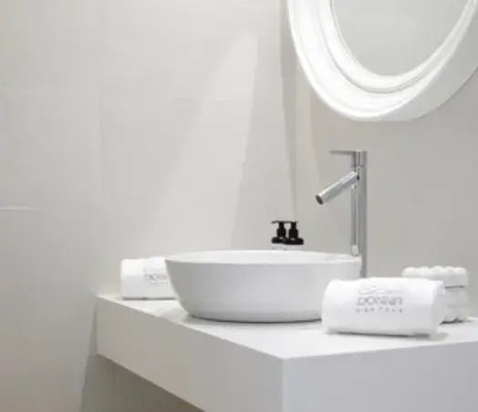 Minimalistisches Badezimmerdesign mit ovalem Waschbecken und Rundspiegel