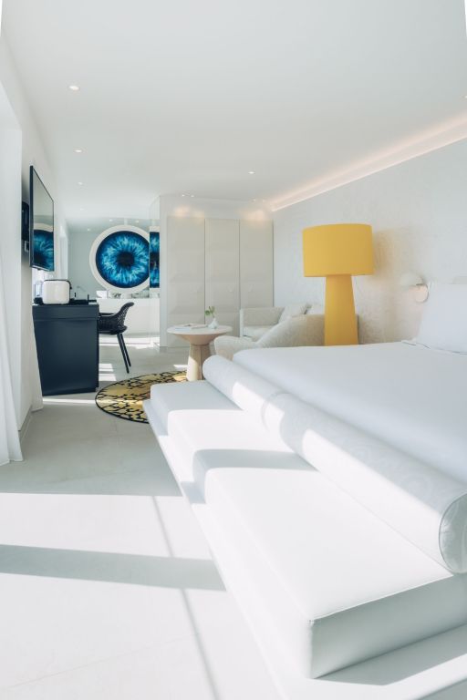 Lichtdurchflutetes Zimmer mit großem Bett, Blick aufs Badezimmer