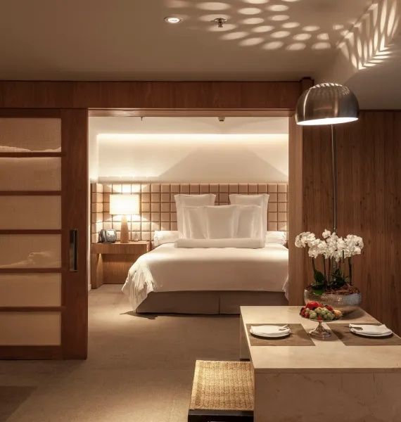 Große Suite mit Doppelbett, gedecktem Esstisch und Holzverkleidungen.