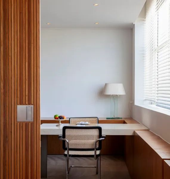 Moderner Arbeitsbereich mit Schreibtisch, Stuhl und Schiebetür aus Holz.