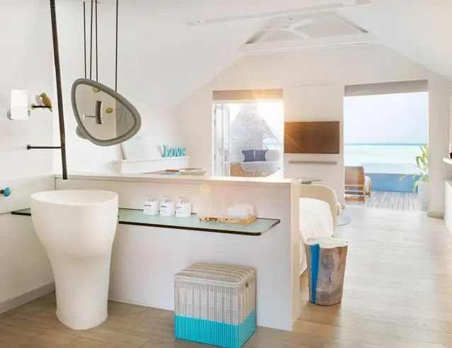 Offener Bereich einer Suite mit modernem Waschtisch und Ausblick auf das Meer.