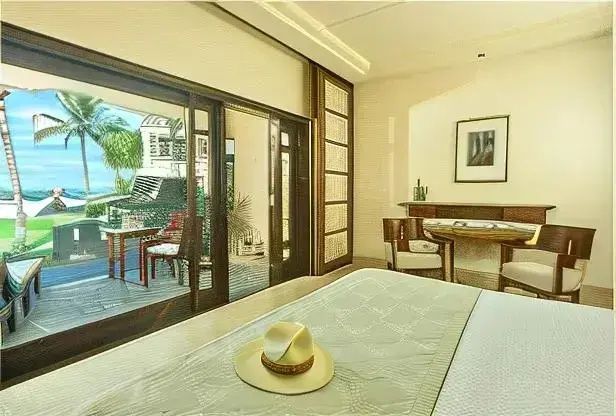 Helles Hotelzimmer mit Doppelbett, Schreibtisch und großer Schiebetür zur privaten Terrasse.