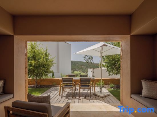 Blick von einer überdachten Terrasse auf einen Sitzbereich im Freien.