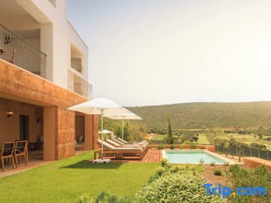 Gartenbereich einer Suite mit privatem Pool, Liegestühlen, Sonnenschirmen und Landschaftsblick.