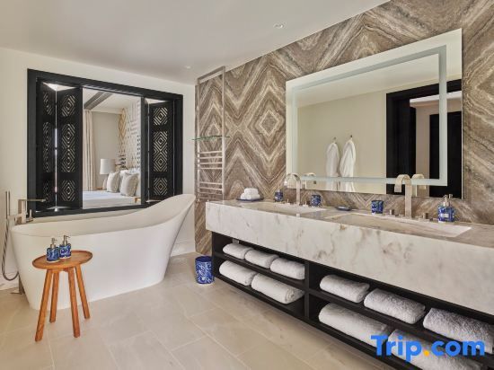 Modernes Badezimmer mit freistehender Badewanne, Doppelwaschtisch und Holzfensterläden zum Schlafzimmer.