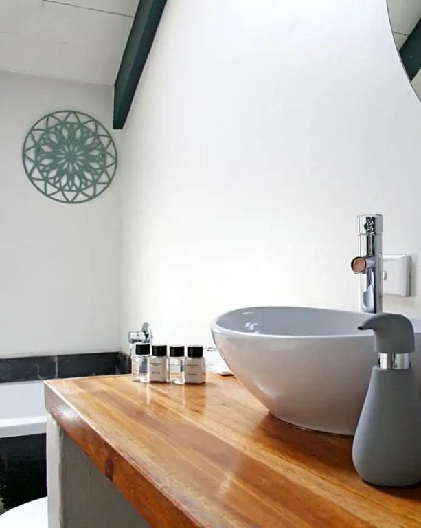 Weißes Badezimmer mit stilvollem Waschbecken und dekorativen Elementen
