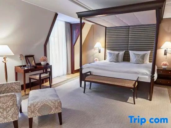 Luxuriöses Schlafzimmer der Brandenburg Gate Deluxe Suite mit Himmelbett und Schreibtisch