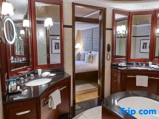 Badezimmer mit Doppelwaschbecken und Sicht auf das Schlafzimmer in der Deluxe Suite
