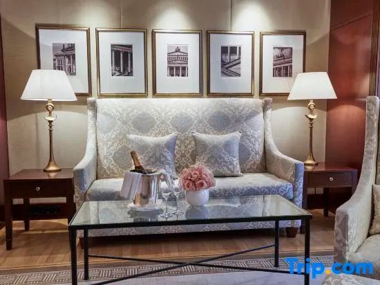 Sitzbereich mit Sofa und Bildergalerie über einem Glastisch in der Deluxe Suite