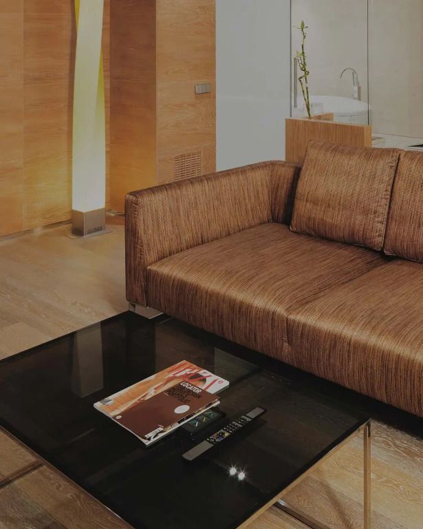 Gemütliche Sitzecke mit modernem Sofa und Glastisch im Hotelzimmer.