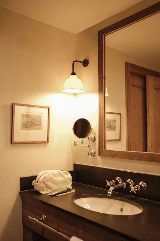 Badezimmer mit beleuchtetem Spiegel und Waschbecken im Chic-Design