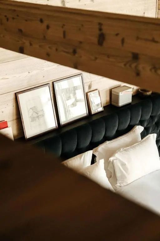 Kunstwerke und Kopfteil auf einem Bett im stilvollen Hotelzimmer