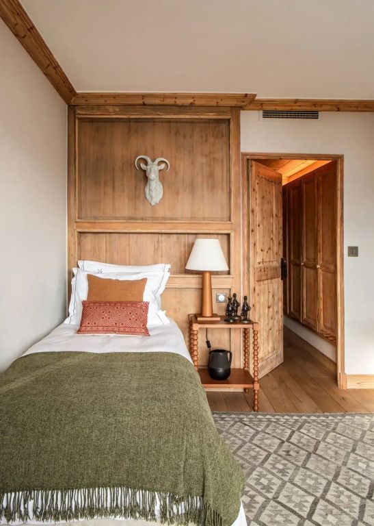 Einzelbett in der Deluxe Suite mit warmen Holzakzenten und geschmackvollen Verzierungen