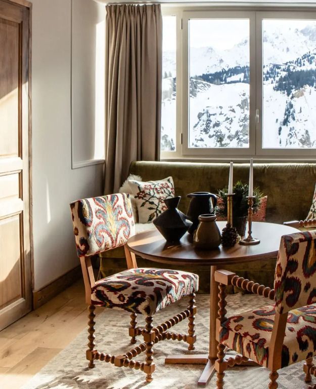 Wohnbereich mit Panoramablick auf verschneite Landschaft in der Deluxe Suite