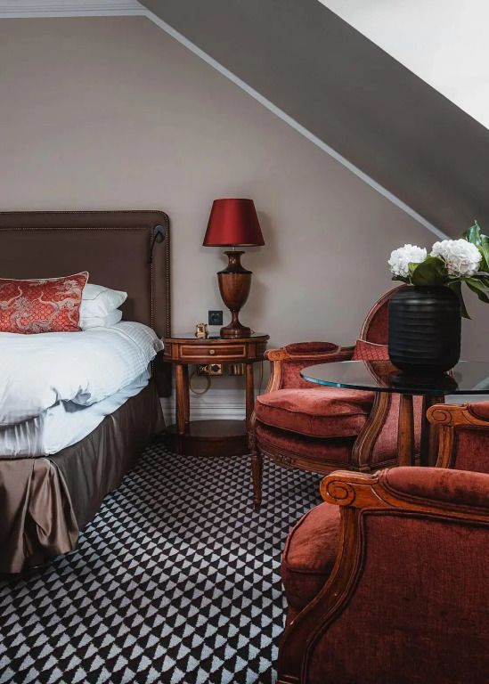Gemütliche Sitzgruppe in der Junior-Suite mit Retro-Möbeln und Blumen
