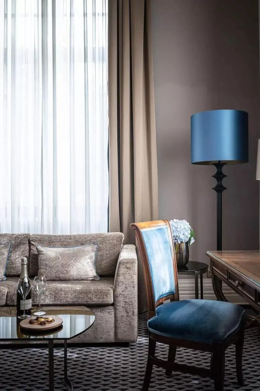 Eleganter Sitzbereich mit blauem Stuhl, Sofa und Champagner.