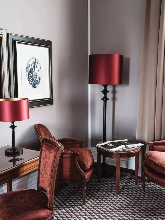 Sitzecke im Grand Superior Doppelzimmer mit roten Stühlen und moderner Stehlampe