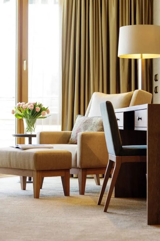 Stilvolle Sitzecke in einem Standardzimmer mit Blumen und Schreibtisch