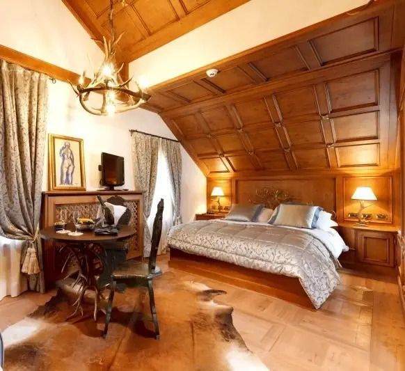 Luxuriöses Schlafzimmer im Hotel Ambra Cortina mit rustikalen Holzelementen und Kunstwerk