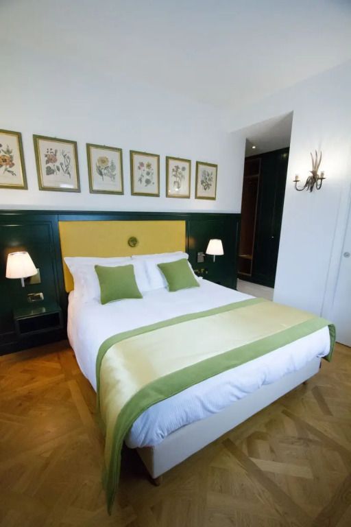 Gemütliches Doppelbett in modernem Zimmer mit grünen Akzenten und botanischen Bildern