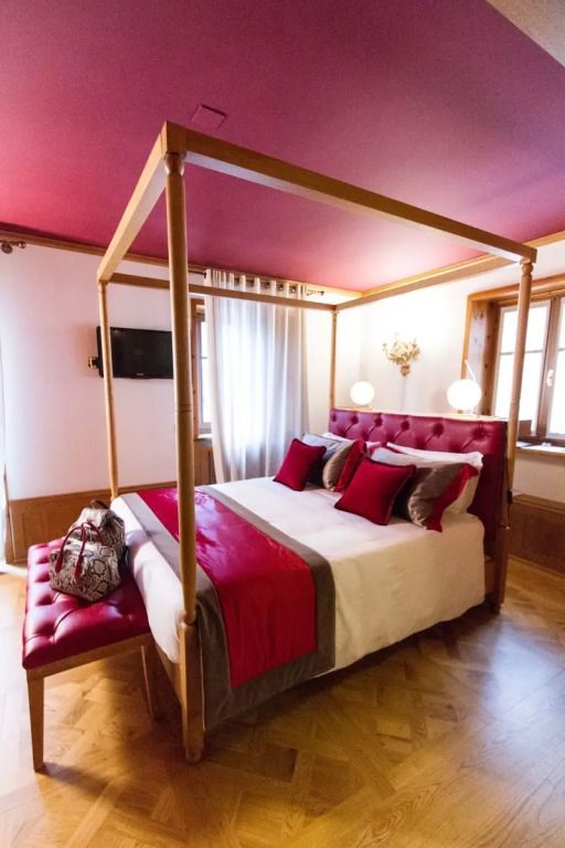 Elegantes Doppelzimmer mit roter Bettwäsche und klassischem Dekor.