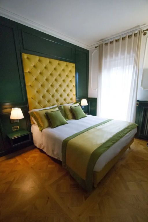 Elegantes Doppelzimmer mit grünem und gelbem Dekor und luxuriösem Kopfteil