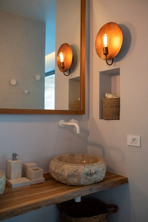 Modernes Badezimmer mit eleganter Steinwaschschüssel und stilvoller Beleuchtung