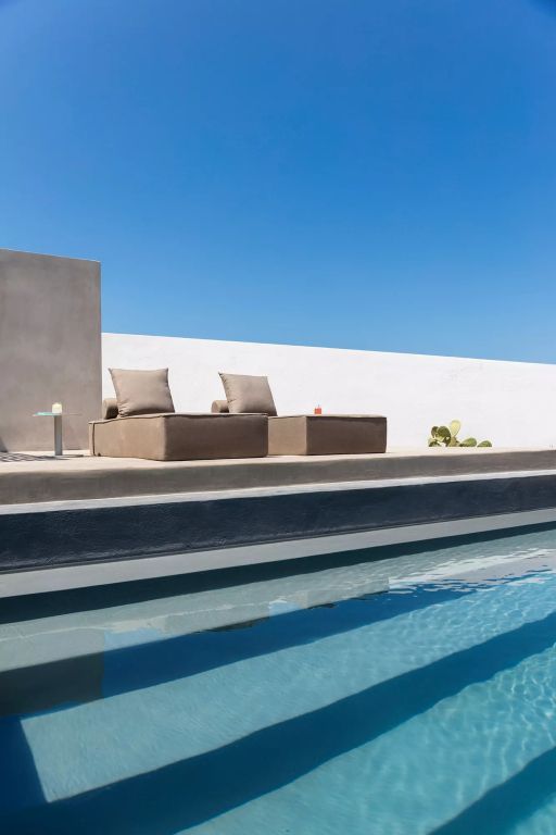 Zwei Liegen am Rand eines modernen Pools