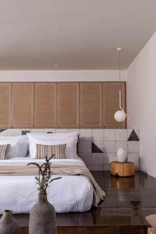 Detailansicht eines stilvollen Bettes mit Holz- und Keramikelementen in der Sunset Suite