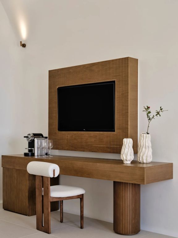 Stilvoller Schreibtisch mit Fernseher und dekorativen Elementen.