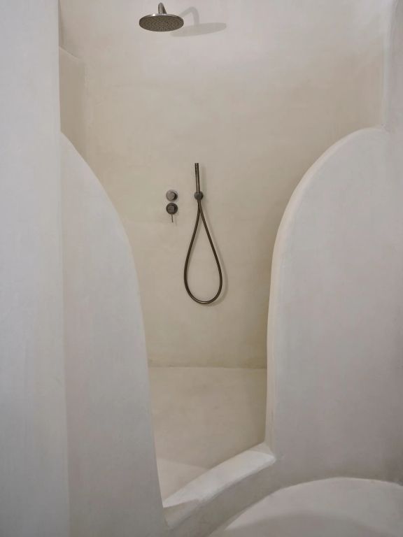 Moderne Dusche mit abgerundeten Wänden und hochwertiger Duscharmatur.