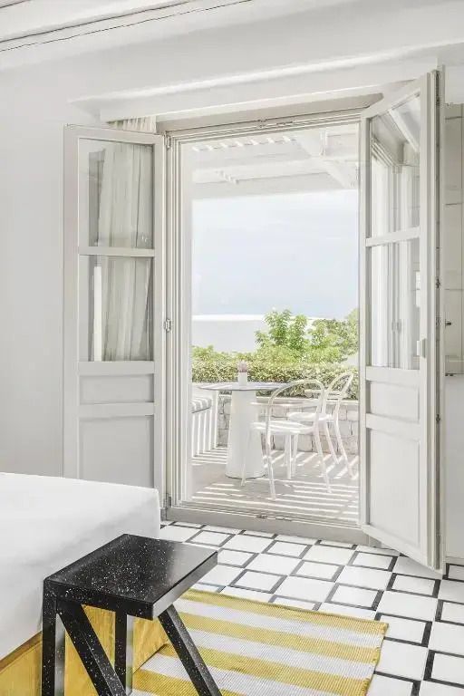 Ausblick vom Zimmerbalkon auf das Meer und die umliegende grüne Landschaft.
