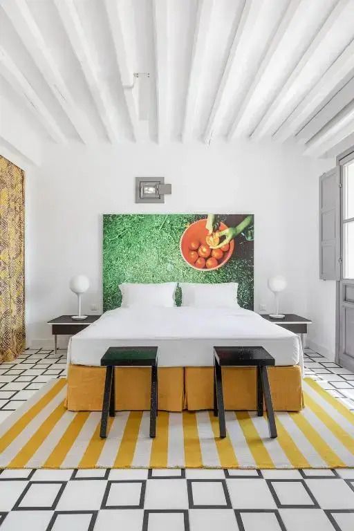Helles Schlafzimmer mit Doppelbett und künstlerischem Wanddekor
