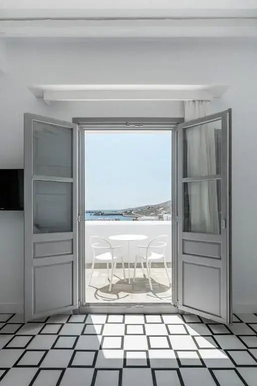 Blick auf den Balkon mit Meer und Berglandschaft durch große Terrassentüren