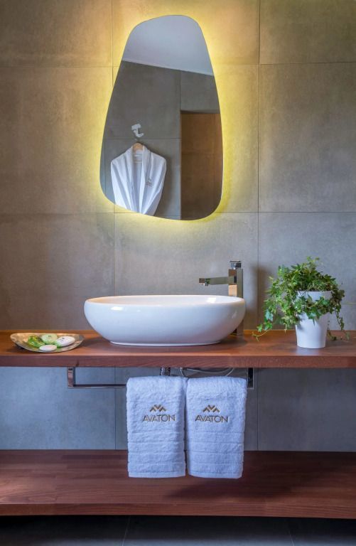 Modernes Badezimmer mit stilvollem Waschbecken und beleuchtetem Spiegel