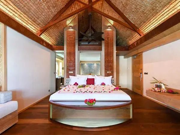 Großzügiges Schlafzimmer mit Holzdecke und exotischer Dekoration