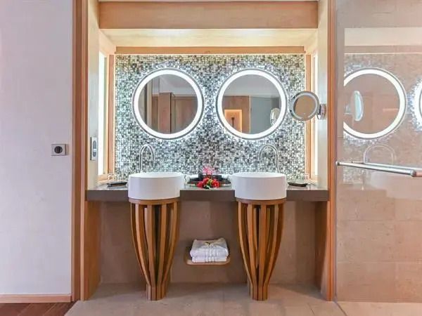 Doppelwaschbecken mit stilvoller Beleuchtung und Mosaik-Wandverkleidung