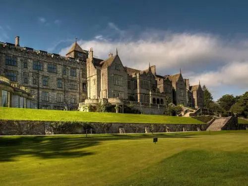 Historische Schlossfassade des Bovey Castle mit gepflegtem Rasen im Vordergrund