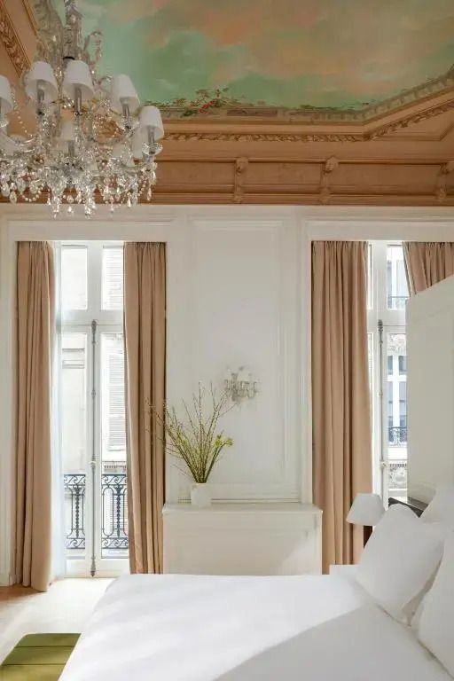 Helles Schlafzimmer mit großen Fenstern und Vorhängen